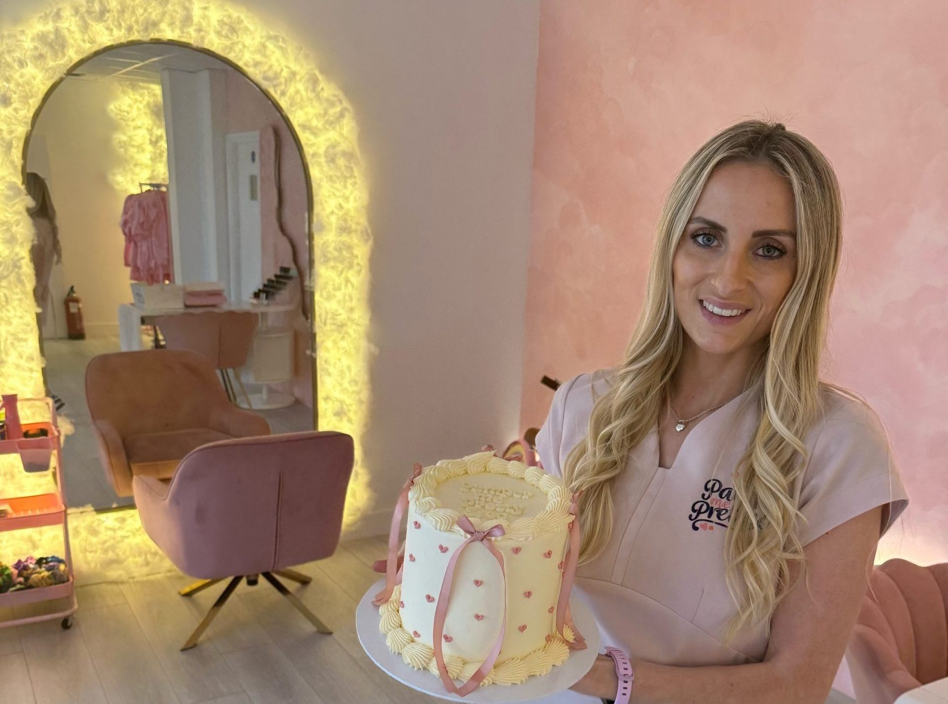 Pamper Me Pretty founder holding a celebration cake in the salon showcases the Pamper Parties in Brentwood